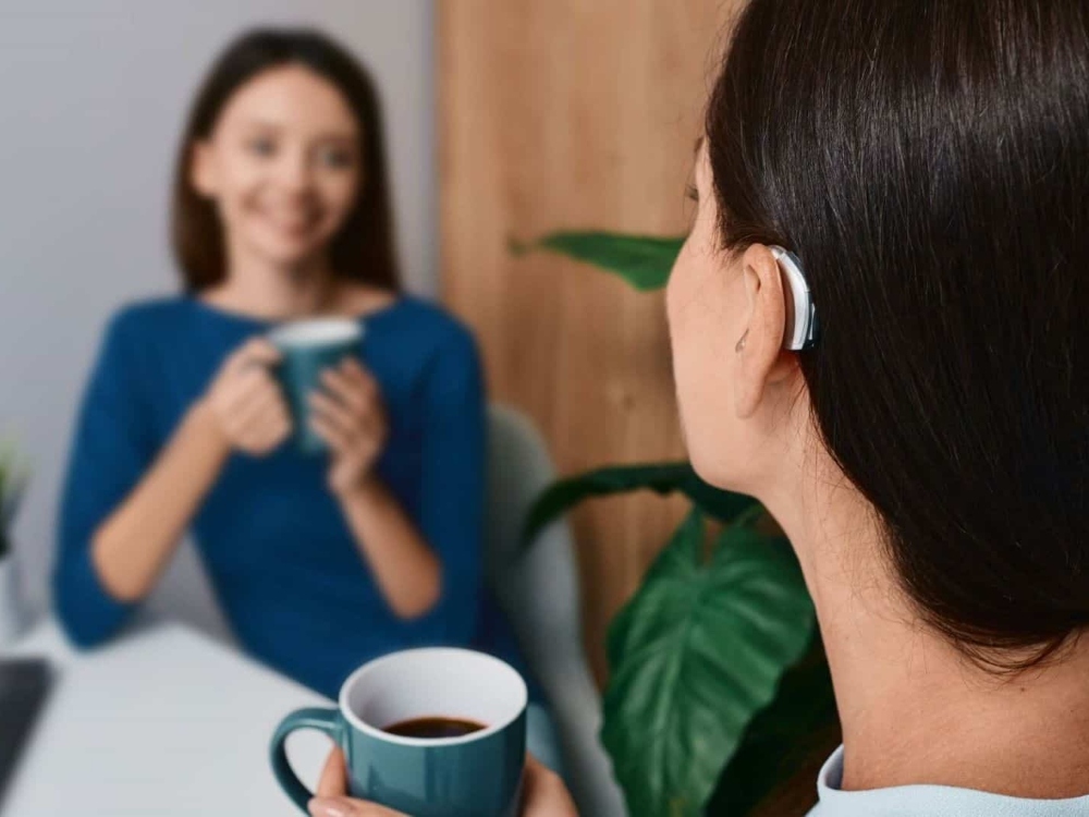 Woman wearing a receiver-in-canal hearing aid, one of several hearing aid styles fitted at Hughes Holistic Audiology in Zionsville, IN